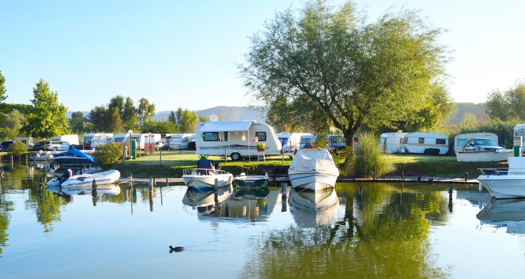 Camping site and community on a lake with rvs and boats