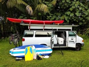 photo of rv camper van in hawaii with surfboards 