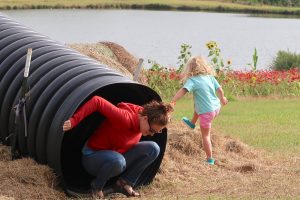 mother and daughter play on playground slide